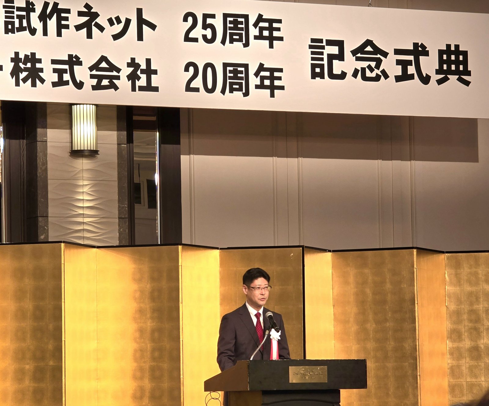 記念式典で挨拶する名高新悟