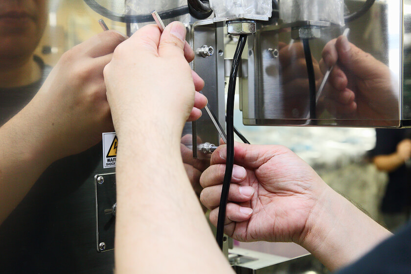 Worker fitting a component to equipment with a tool
